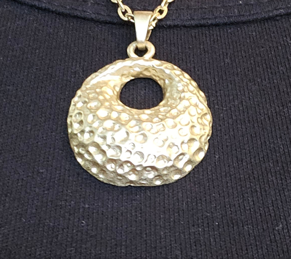 Gold necklace with round textured pendant
